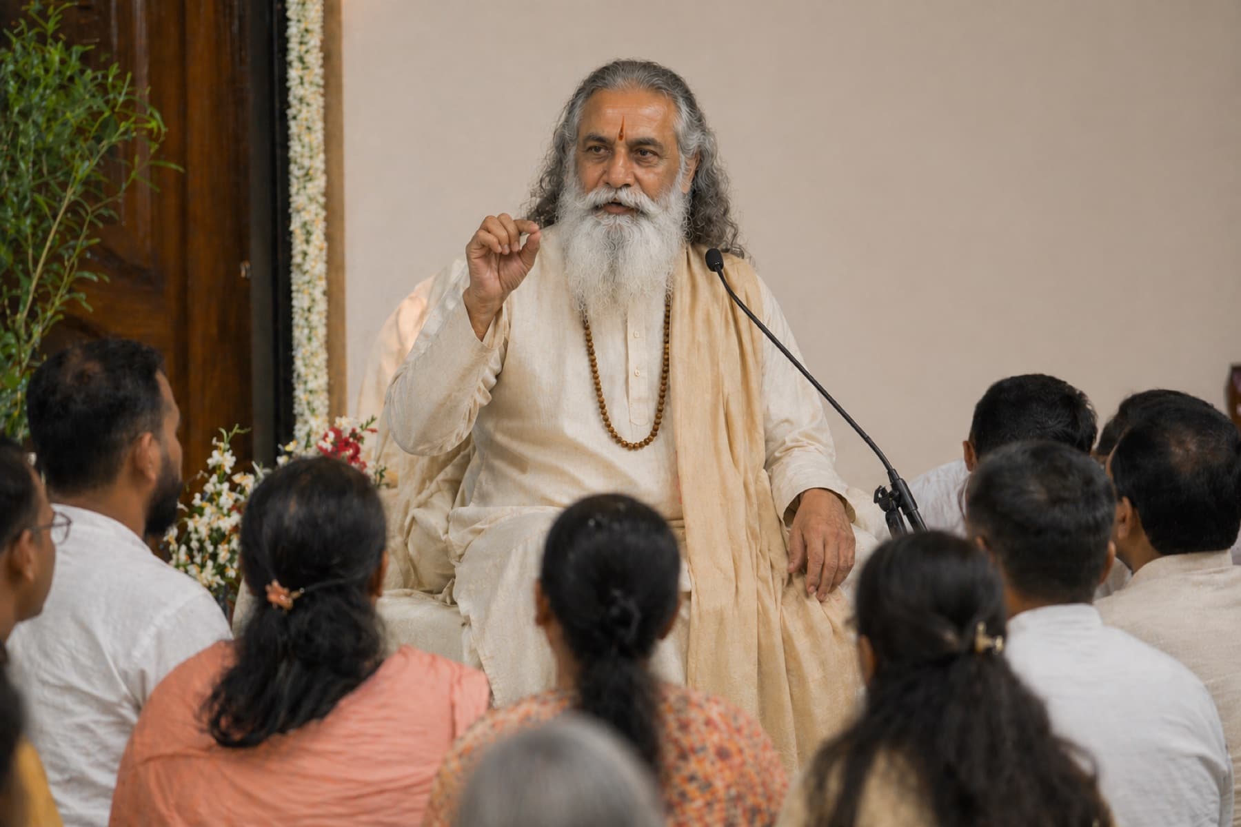 Swami Parashar in saffron-cream robes, seated in quiet contemplation.